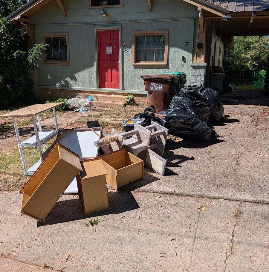 Before: furniture, shelving, and bagged trash piled in a driveway in Davie County NC